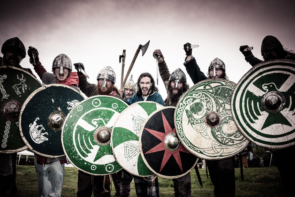 Viking re-enactors with round shields and weapons aloft